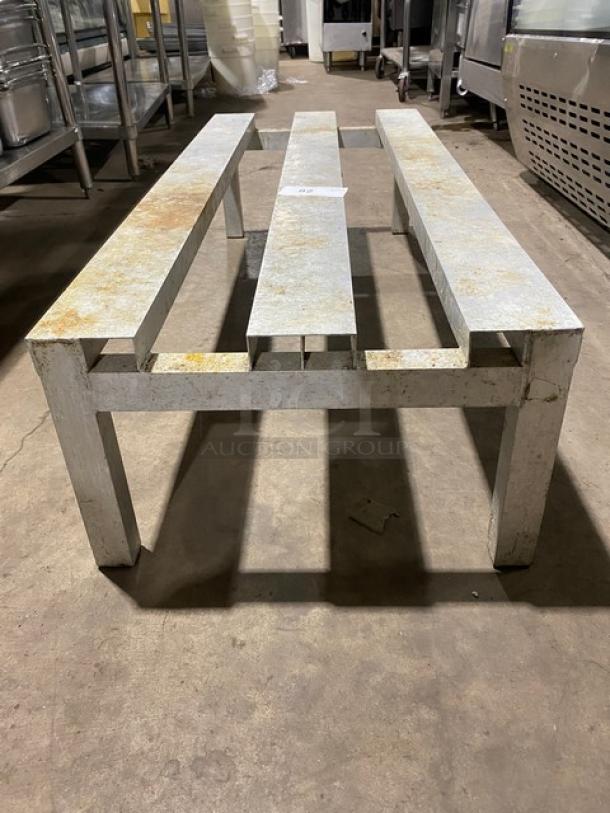 Commercial heavy-duty dunnage rack on legs, metal construction, slight surface rust, sturdy design, ideal for storage.