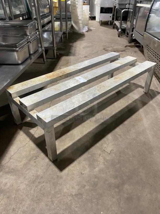 Commercial heavy-duty dunnage rack on legs, metal construction, visible wear and rust, durable for industrial use.