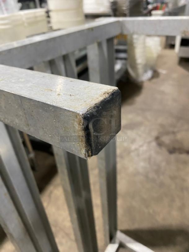 Commercial heavy-duty dunnage rack with legs, metal construction, used condition with wear, ideal for storage.