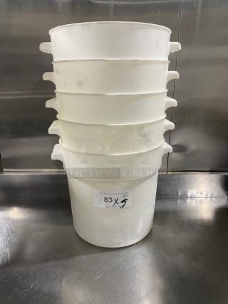 Stack of five white round commercial food storage containers with handles, slightly used. Label indicates lot number 83.