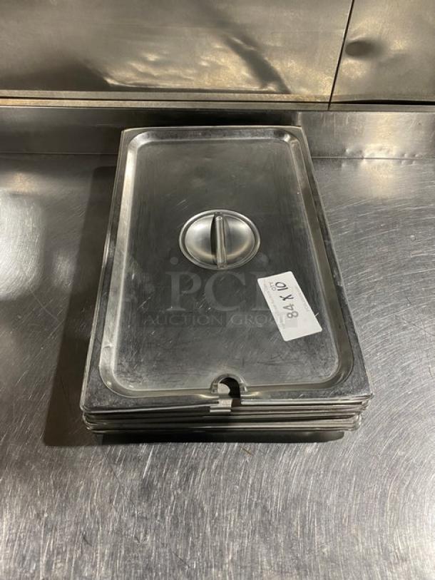 Stainless steel steamtable pan lid with notch, stack of lids, polished finish, good condition, auction tag "84 K/O".