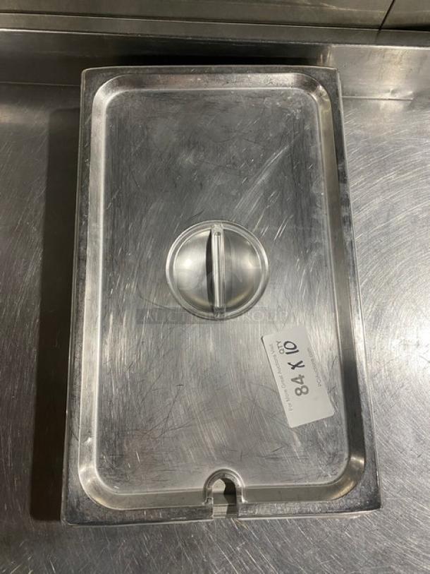 Commercial stainless steel notched hotel/steamtable pan lid, rectangular, with handle. Tag reads "84 X 10." In good condition.