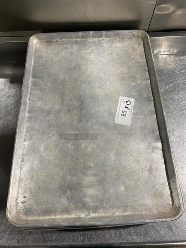 Commercial baking sheet pan, well-used condition. Metallic surface with slight wear. Labeled "85 X 13".
