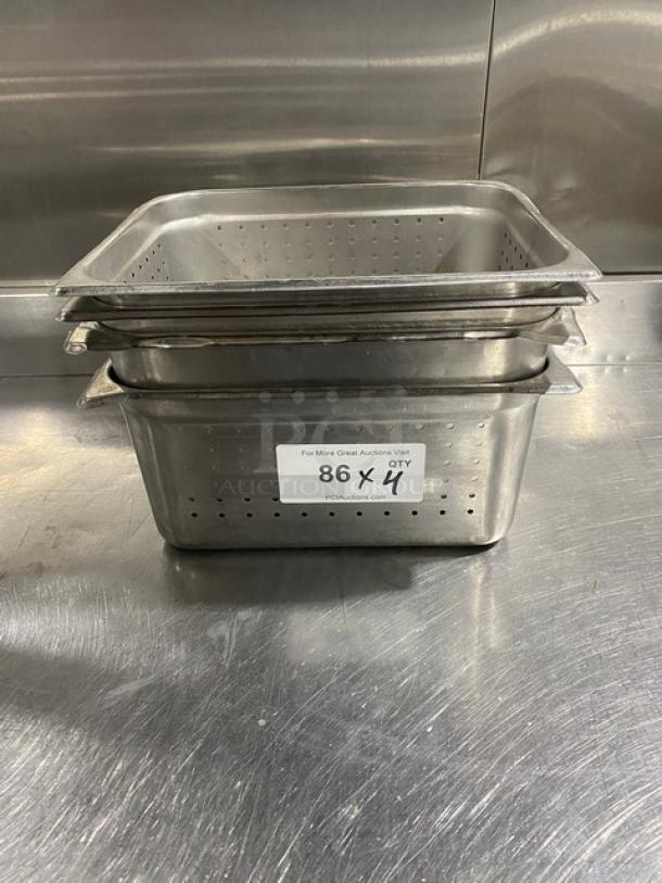 Commercial stainless steel perforated steamtable pans, stack of four, in good condition. Auction label visible on front.