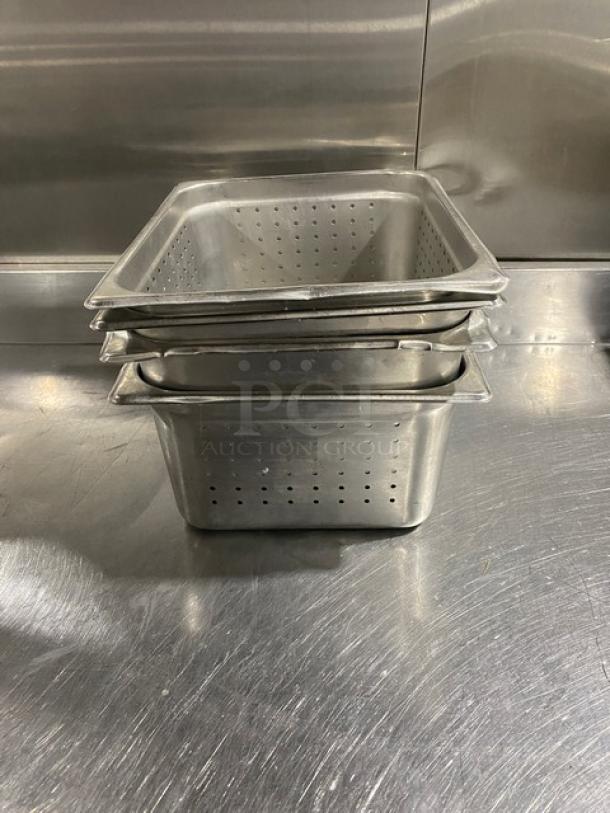 Commercial stainless steel perforated hotel pans, stack of three. Durable, used condition, ideal for steamtable use.