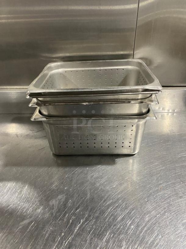 Commercial stainless steel perforated steamtable pans, stack of three. Durable, corrosion-resistant, suitable for hotel use.