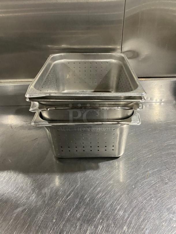 Commercial stainless steel perforated steamtable pans, stack of four, durable, ideal for catering or food service use.