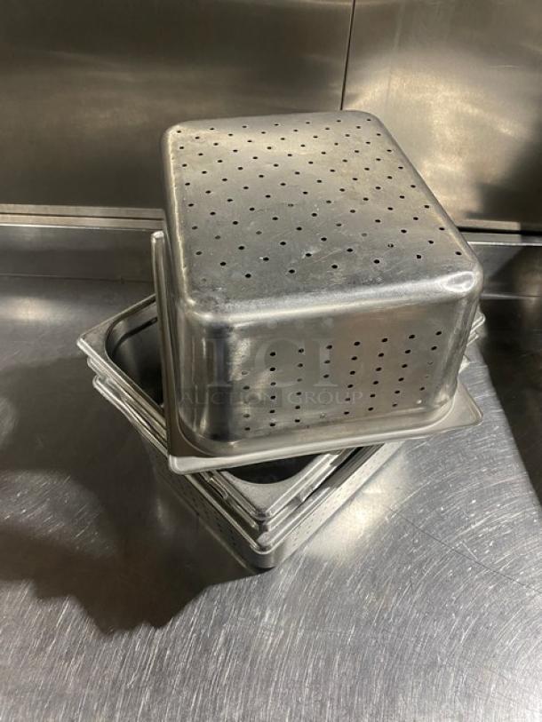 Stainless steel perforated hotel pan, commercial-grade, stack of four. Suitable for steam tables, durable condition.