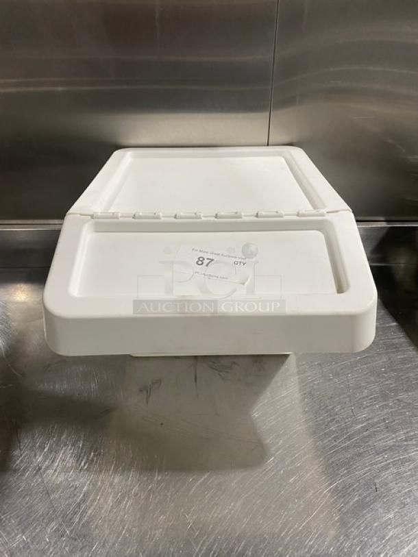 Commercial white stackable countertop food ingredient bin with hinged lid, sticker labeled "87 OTY," on stainless steel surface.