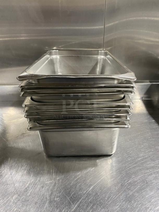 Stack of commercial stainless steel hotel steam table pans in good condition, featuring durable construction and uniform size.