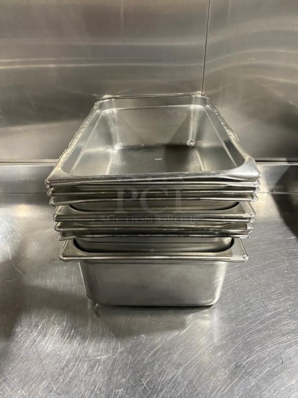 Stack of commercial stainless steel hotel/steamtable pans. Durable, used condition with smooth finish, ideal for catering.