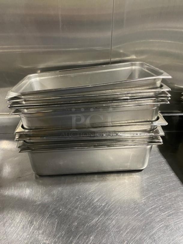 Stack of commercial stainless steel hotel steamtable pans, used condition, showcasing durable construction and versatility.