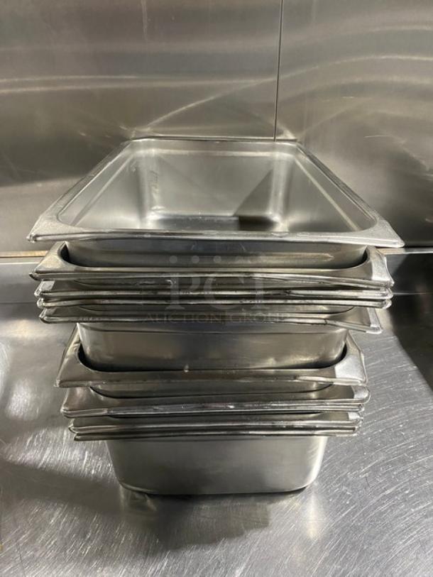 Stack of commercial stainless steel hotel/steamtable pans, pristine condition, ideal for catering or restaurant use.