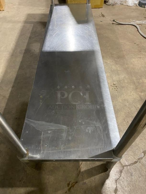 Commercial stainless steel worktop table with single undershelf and up-turned backsplash on legs. Used condition.