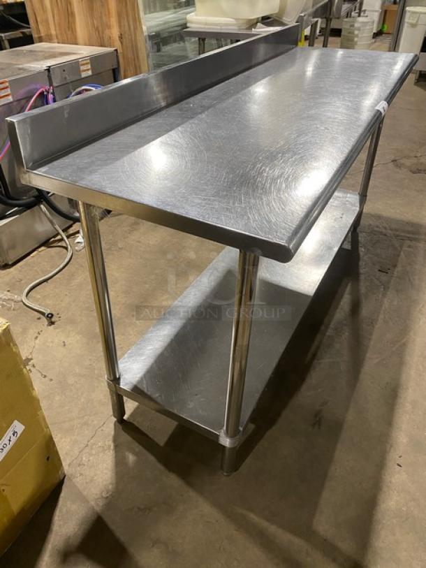 Commercial stainless steel worktop table with undershelf and upturned backsplash, supported by sturdy legs.
