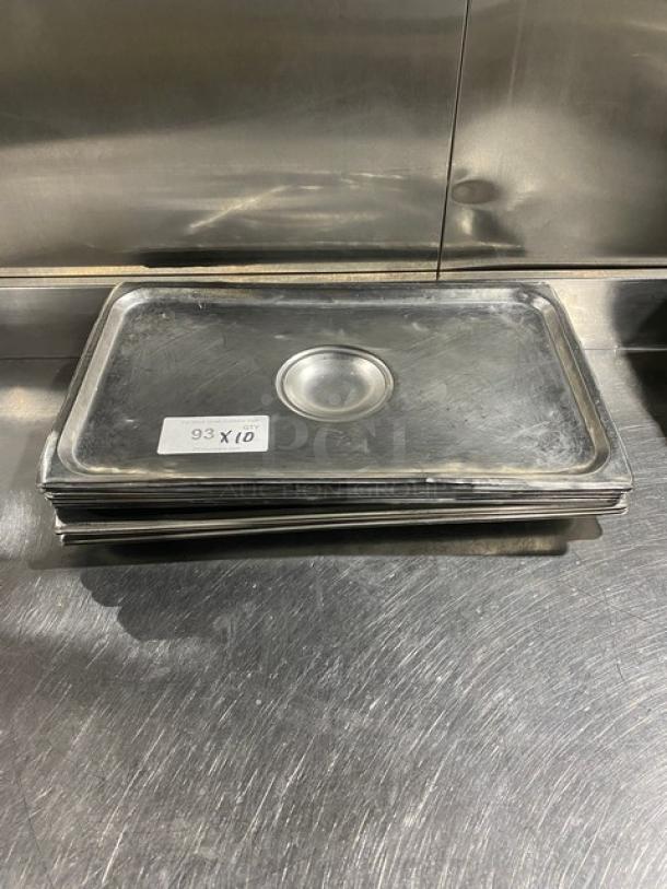 Stainless steel steamtable pan lid stack with central handle, labeled "93 X 10" indicating quantity. Used condition.