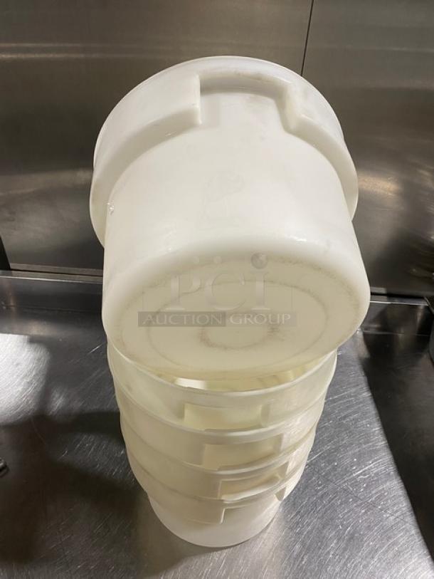 Commercial white round food storage container with handles, stackable, shown in used condition.