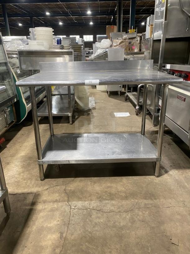 Commercial stainless steel worktop table with undershelf, up-turned backsplash, and sturdy legs. Good condition.