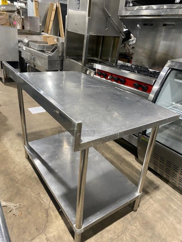 Commercial stainless steel worktop table with undershelf and up-turned backsplash. On legs. Used condition.