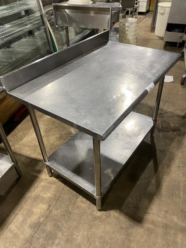 Commercial stainless steel worktop table with single undershelf, up-turned backsplash, and sturdy legs. Excellent condition.