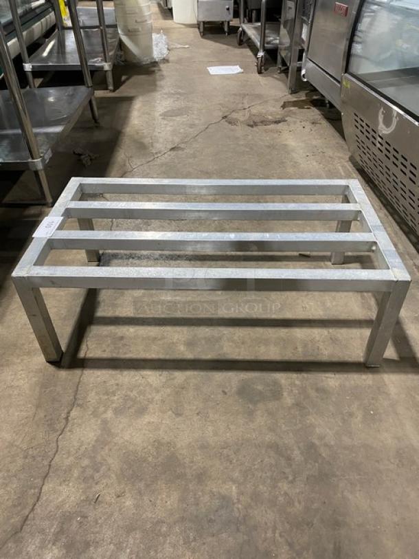 Commercial heavy-duty dunnage rack on legs. Metal construction, four bars, sturdy design. Good condition. Ideal for storage.