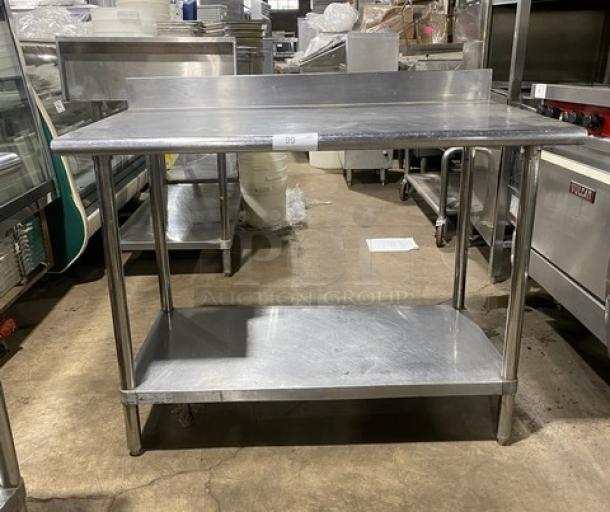 Commercial stainless steel worktop table with undershelf, up-turned backsplash, and sturdy legs. Good condition.