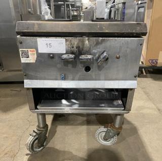 Commercial stainless steel natural gas single burner stock pot range on casters, used condition, three control knobs visible.