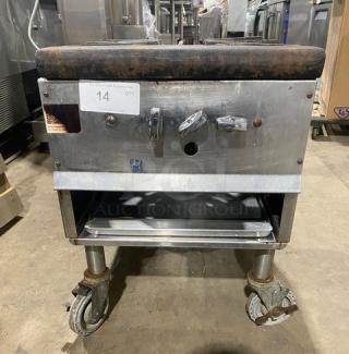 Commercial stainless steel single burner stock pot range, natural gas powered, with casters. Some wear visible.