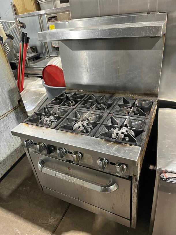 Qualite stainless steel 6-burner range/oven combo, natural gas, with backsplash, salamander shelf, wired rack, on legs.