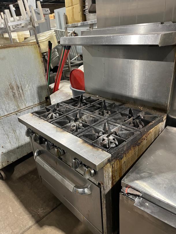 Qualite commercial stainless steel 6-burner gas range/oven combo with backsplash, overhead salamander shelf, wired oven rack, on legs.