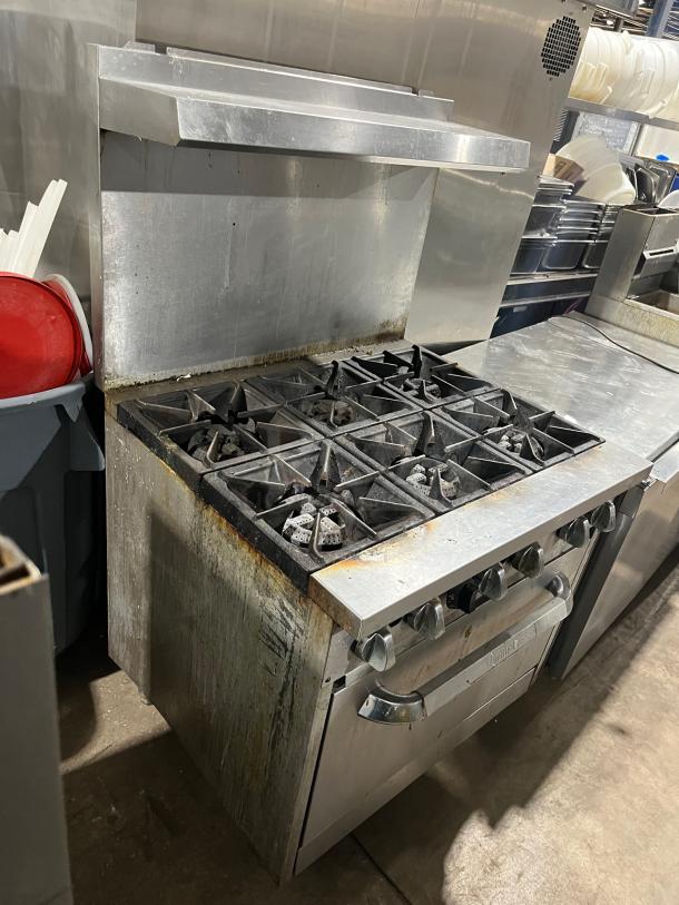 Qualite commercial stainless steel 6-burner range/oven combo with backsplash, overhead salamander shelf, and wired oven rack.