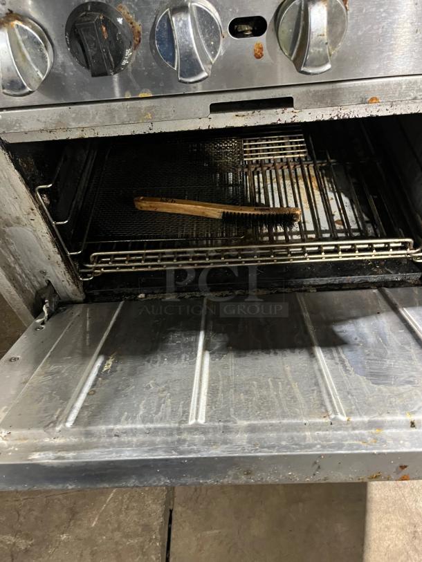 Qualite commercial stainless steel 6-burner range/oven combo with wired oven rack, backsplash, salamander shelf; natural gas-powered.