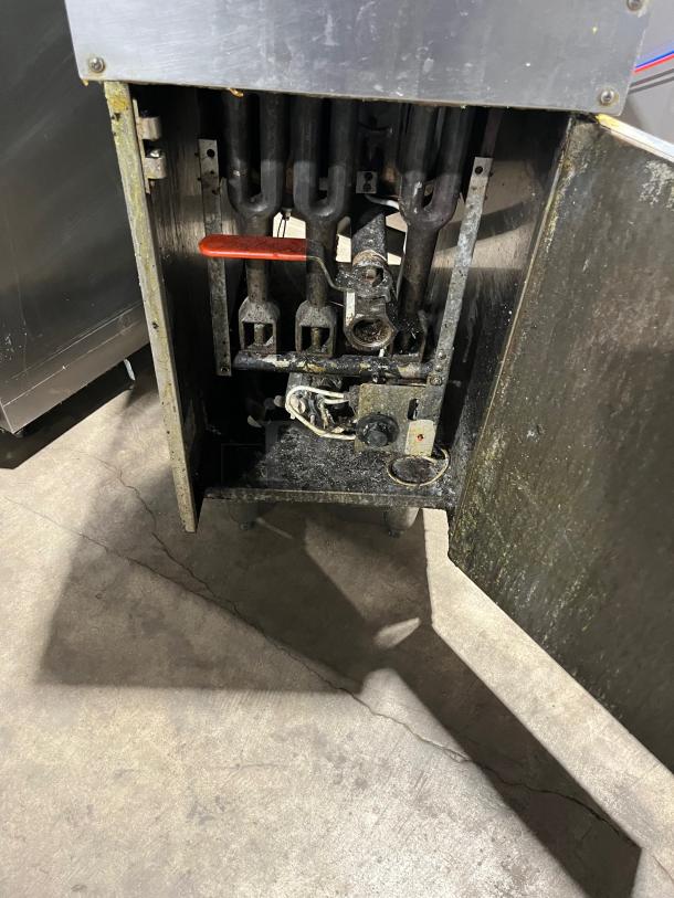 DCS stainless steel deep fat fryer with backsplash, basket hanger, and gas burners exposed. Good condition, on legs.