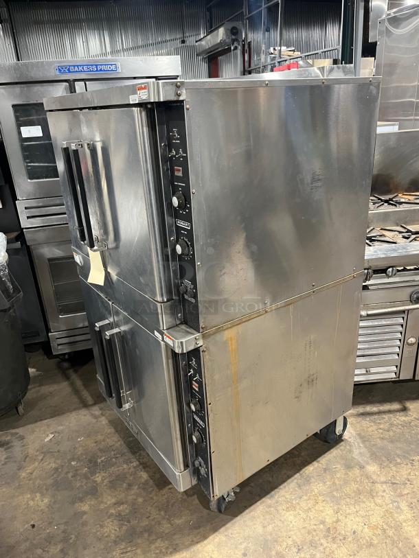 Hobart stainless steel double stacked convection oven, electric powered, with wired rack. On casters, in used condition.