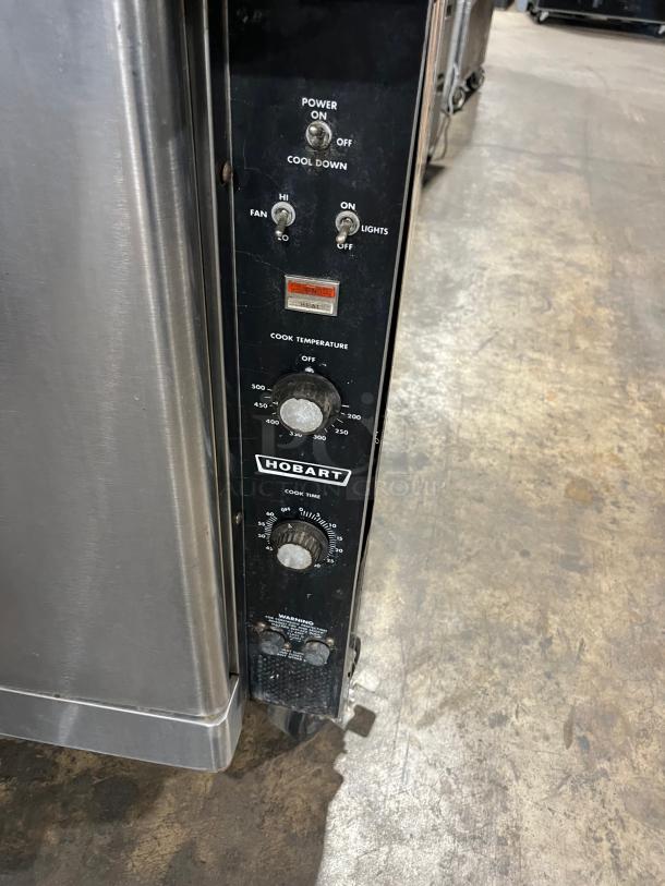 Hobart stainless steel electric convection oven, double stacked, on casters. Control panel shows power, fan, temperature dials.
