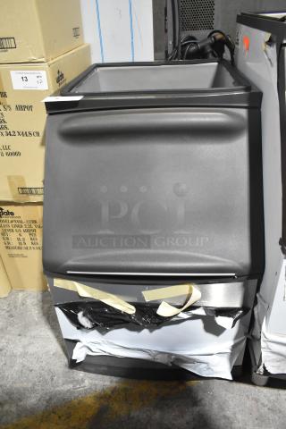"Brand new Manitowoc B320 stainless steel ice bin, 210 lb. capacity, shown with minor scratches and dents, boxed."