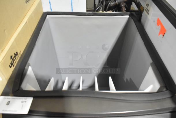 Brand new Manitowoc B320 stainless steel ice bin, 210 lb capacity, with minor scratches and dents, no visible markings.