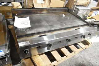Garland stainless steel commercial countertop flat top griddle with control knobs, fair condition, on a wooden pallet.