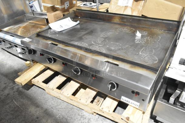 Garland stainless steel commercial countertop flat top griddle, four burners, used condition, visible Garland label.