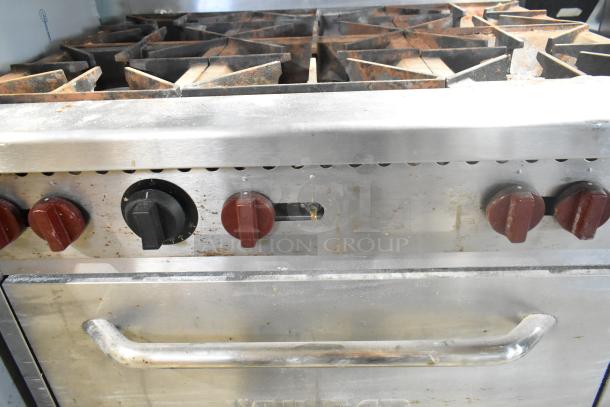 Vulcan stainless steel gas 6-burner range with oven, over shelf, back splash. Used condition with visible knobs and handle.