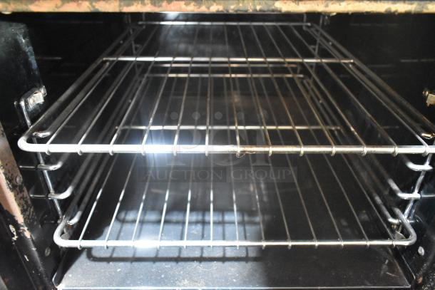 Stainless steel oven interior of Tri-Star TSR-1 with metal racks, showing moderate wear, ideal for commercial kitchen use.