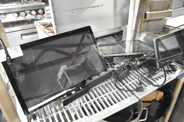 Three POS monitors with cables on metal shelf; includes Toast brand labels; condition appears used.
