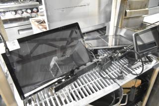 Three POS monitors with cables on metal shelf; includes Toast brand labels; condition appears used.