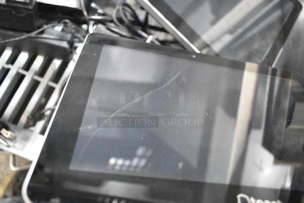 Three POS monitors stacked, showing visible scratches on screens. Black casings with some cables visible, indicative of used condition.