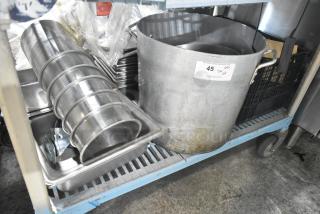 Metal stock pot and stainless steel cylindrical bins in used condition with auction tag labeled "45 QTY".
