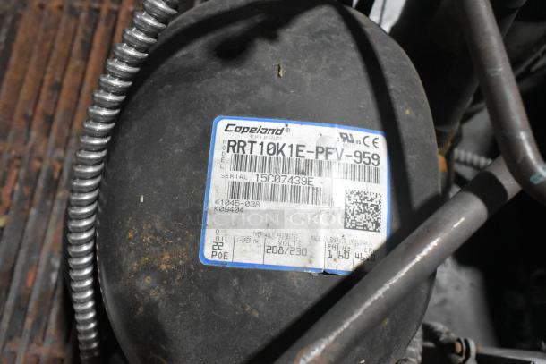 Copeland RRT10K1E-PFV-959 commercial compressor with label, 208/230V, 1 Phase, metal construction, minor surface wear.