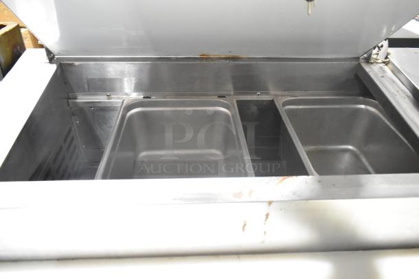 Avantco 178PICL2 stainless steel commercial pizza prep table, 115V, 1 phase, features multiple compartments, visible wear.