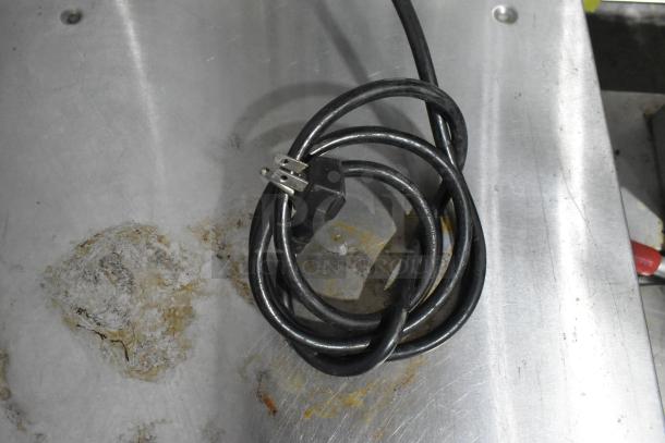 Coiled power cord for Alto Shaam 300-TH/III oven on a stainless steel surface, showing signs of wear.