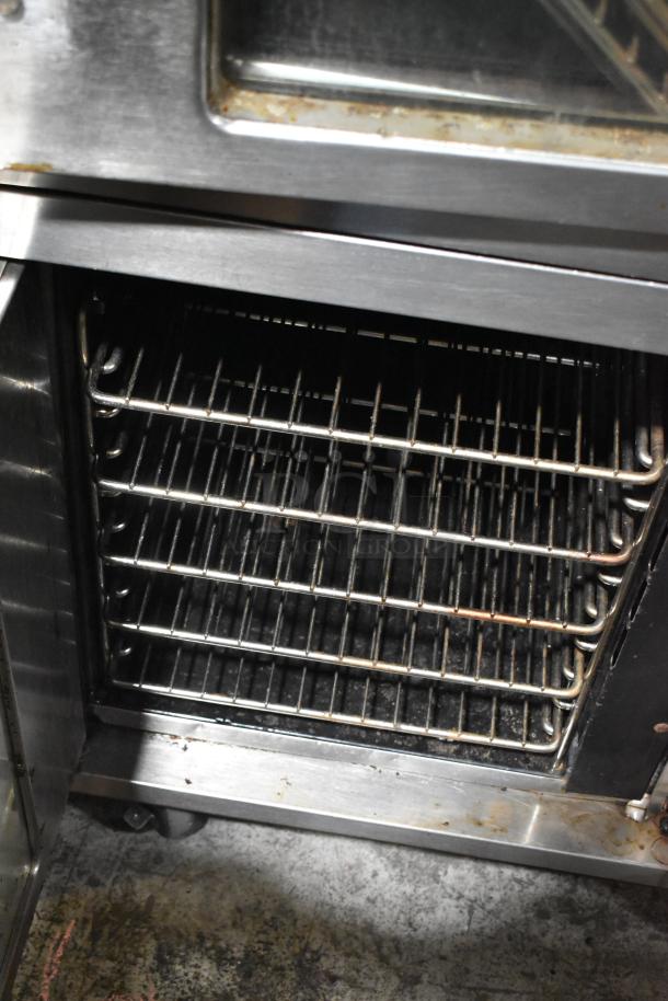 Vulcan stainless steel commercial gas convection oven, half size, multiple racks, visible wear, ideal for restaurant use.