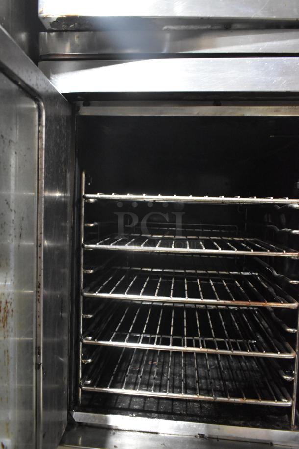 Vulcan stainless steel commercial half-size convection oven, gas-powered, interior view with multiple racks, in used condition.